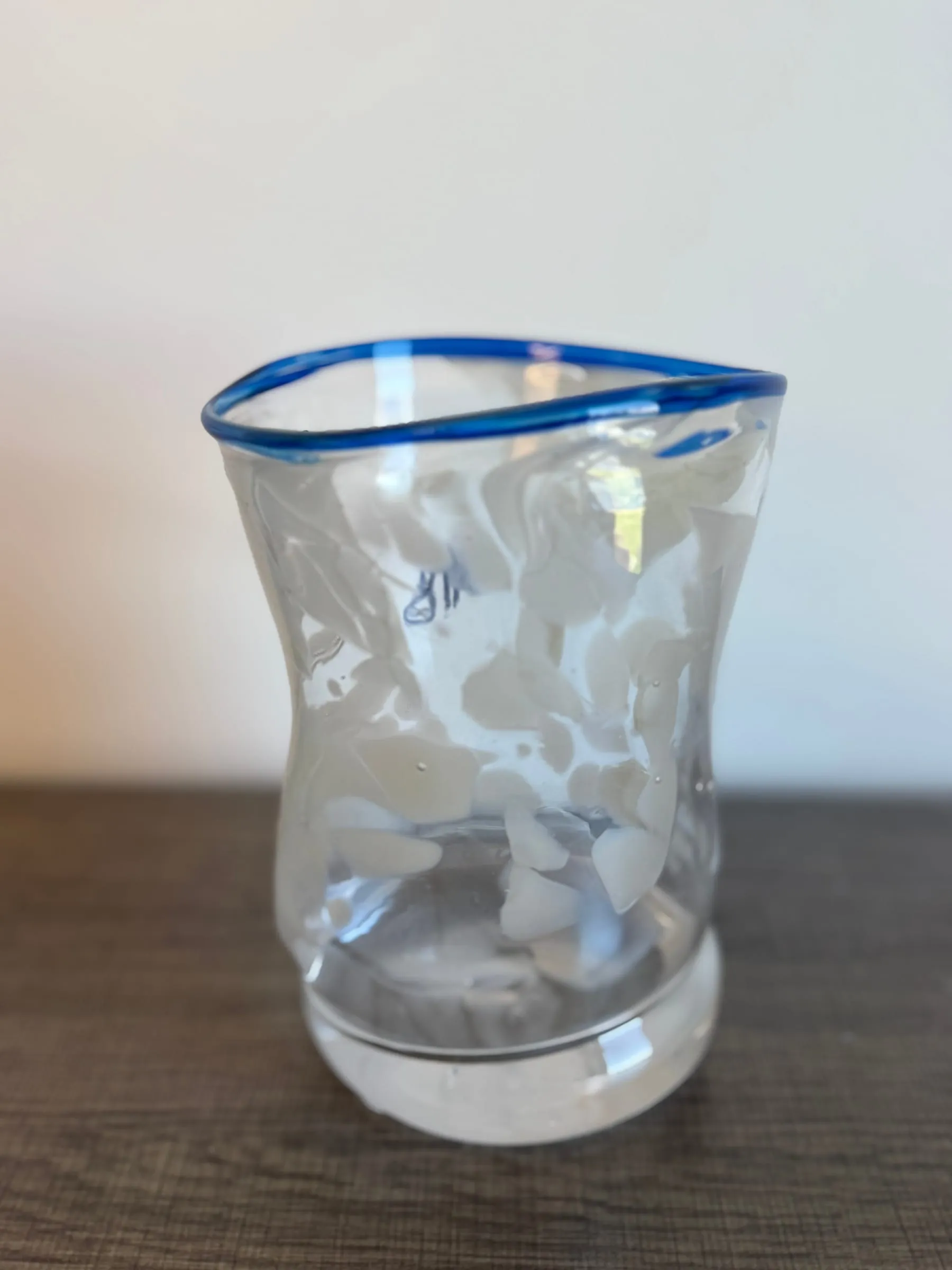A cup with white frit and a blue lip wrap